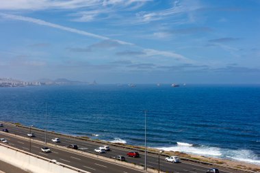 Büyük Kanarya 'da Ocean View ile Sahil Yolu. Yüksek kalite fotoğraf, Gran Canaria 'da bir sahil otoyolunun manzarası. Mavi okyanus kıyısında dağınık bulutlu güneşli bir gökyüzü altında giden arabalar..