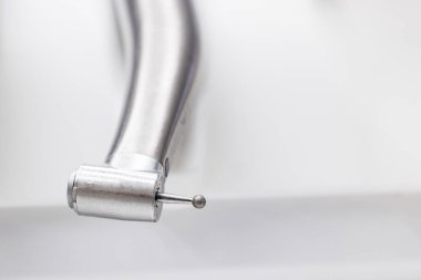 Diş tedavisi ışığı ve burr ile türbin el aleti. Yüksek kaliteli fotoğraf, Macro iyileştirici prosedürlerde kullanılan yuvarlak burr takılı türbin el çantasının yanındaki diş macununun görüntüsü.. 