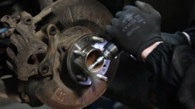 Bir tamircinin tekerlek boşluğu kurmak için ingiliz anahtarı kullandığının yakın plan video kasedini Oto Hub 'a kuruyor. Yüksek kalite 4k görüntü