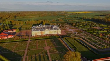 Letonya 'daki Rundale Sarayı' nın hava görüntülerinde simetrik Barok bahçeleri, tarihi mimari ve kırsal manzaralar altın saat boyunca sergilenmektedir. Yüksek kalite 4k görüntü