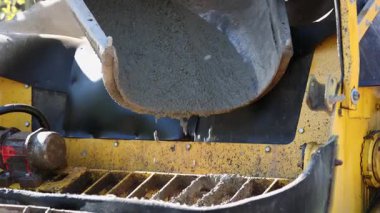 Karıştırıcı kamyonundan Hopper 'a beton dökülüyor. İnşaat makinesinin kapısına ıslak beton dökülüyor.