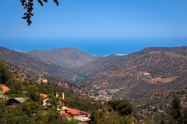 Kıbrıs Rum Kesimi 'nin yukarıdan manzaralı dağ köyü görüntüsü, tepeler ve ormanlar arasında kurulmuş bir dağ köyünün panoramik görüntüsünü gösteriyor