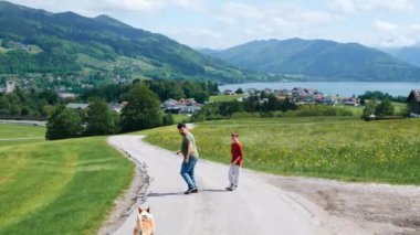 Erkekler, baba ve oğul, bir Corgi köpeğiyle Alpler 'de oynuyorlar. Yüksek kalite 4k görüntü