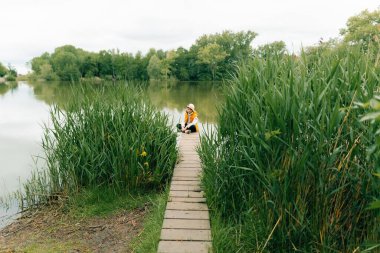 Genç bir çocuk tek başına köprüdeki gölette oturup düşünür. Yüksek kalite fotoğraf