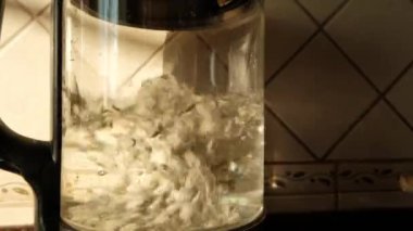 Mutfak tezgahında kaynamış su ve çay yaprakları olan bir çaydanlık sıcak bir atmosfer yaratır.