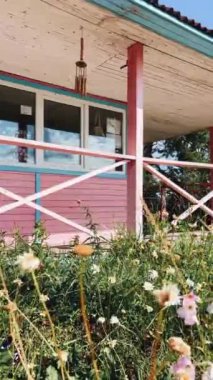 Pembe aksanlı, rengarenk bir bahçeyle çevrili, köylü cazibesi ve cazibesiyle dolu eski bir ev.