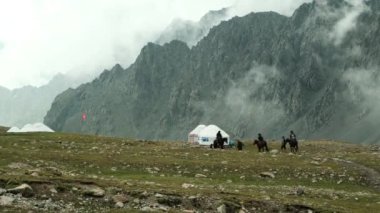 Huzurlu bir dağ kamp alanı dramatik tepelerin altındaki canlı, yemyeşil bir vadide dinlenen atları barındırır.