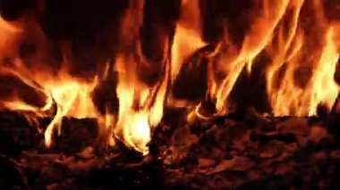 Parlak alevlerin büyüleyici ve canlı bir görüntüsü yanan molozların üzerinde titreşiyor, ateşin saf güzelliğini gösteriyor.