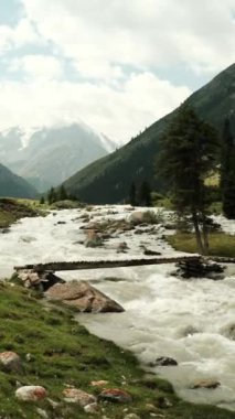 Serin bir nehir yemyeşil ve çarpıcı dağ zirvelerinde akar büyüleyici bir manzara yaratır.