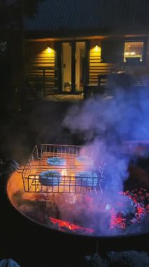 Parlayan kömürlerle dolu, sıcak bir ev ortamı yaratmak için mükemmel ve rahat bir barbekü sahnesi.