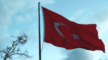 Canlı bir Türk bayrağı bulutlarla dolu şaşırtıcı güzellikteki gökyüzünün altında gururla dalgalanıyor.