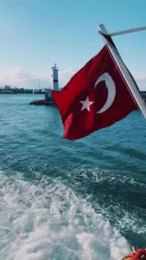 Canlı bir Türk bayrağı zarif bir şekilde dalgalanan bir teknede, okyanusun çarpıcı ve güzel zeminine karşı.
