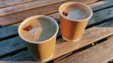 Zarif latte sanatının yer aldığı iki güzel el yapımı kahve fincanı büyüleyici, yıpranmış ahşap bir masanın üzerine konur.
