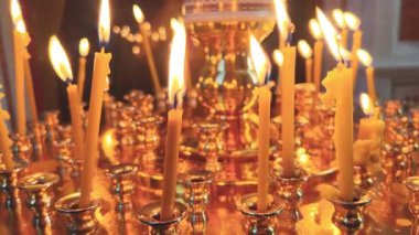 Titreyen mumların sıcak ve davetkar parıltısı göz kamaştırıcı ve dekoratif bir tutucu aydınlatıyor.