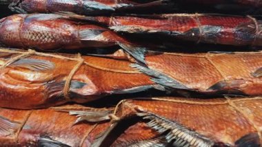 Güzel düzenlenmiş tütsülenmiş balık, renkli sanat eserleri ve geleneksel mutfağın zengin tatları..