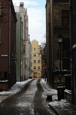 Huzurlu bir Gdansk, Polonya, dar bir sokak yansıtıcı asfalt ve büyüleyici mimari, hepsi bulutlu bir gökyüzüne karşı kurulmuş