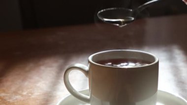 Sıcak bir fincan kahveyle huzurlu bir an, buhar yavaşça havaya yükseliyor, rahatlatıcı bir atmosfer yaratıyor.