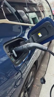 Şarj aleti takılı elektrikli bir araç, eko-dost ulaşımı gösteriyor..