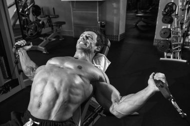 Spor salonunda egzersiz yapan güçlü bir adam.