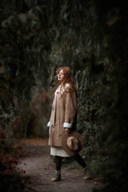 Genç kızıl saçlı kadın sonbahar ormanında