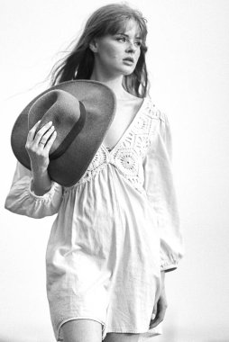 Beyaz elbiseli ve şapkalı güzel bir kız.