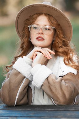 Şapkalı ve gözlüklü güzel bir kadın. sonbahar.