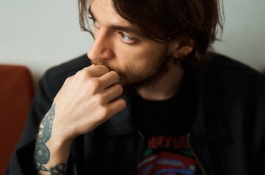 Stüdyoda dövmeli genç bir adamın portresi.