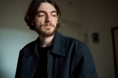 Siyah ceketli ve siyah gömlekli adam.