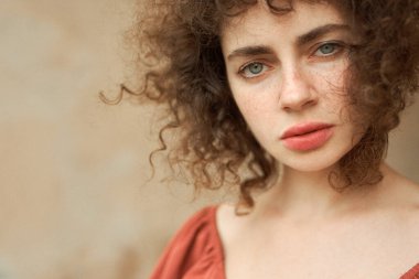 Yakından - güzel kırmızı kıvırcık saçlı kadının çilli portresi.