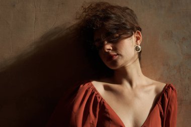 Stüdyoda poz veren kırmızı elbiseli güzel esmer kadın.