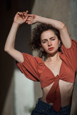 Kırmızı bluzlu ve kot pantolonlu güzel genç manken.