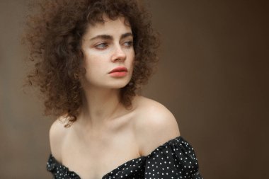 Beyaz gömlekli kadın stüdyo pozu veriyor.