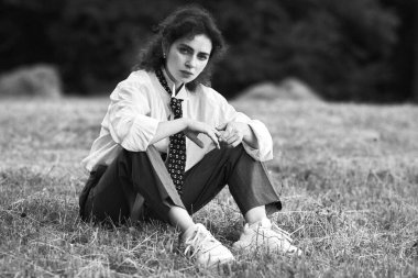 Genç kadın parkta çimenlerin üzerinde