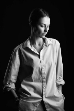 Güzel esmer kadın stüdyoda siyah arka planda poz veriyor.