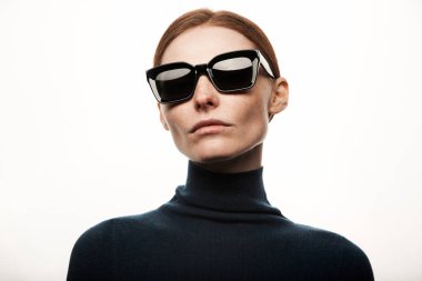 Siyah güneş gözlüklü ve siyah kazaklı güzel bir kadın.