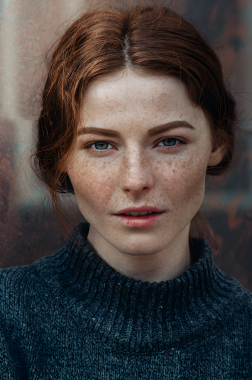 Örgülü süveter giyen genç bir kızılın portresi.