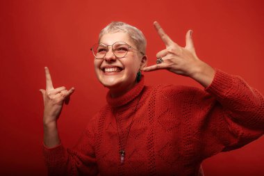 Boynuzları ve boynuzları olan, gri üzerine izole edilmiş parmakları olan son sınıf öğrencisi bir kadın.