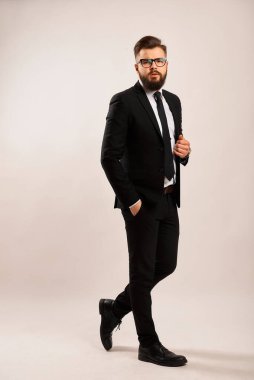 Sakallı, şık siyah ceketli şık bir adam.