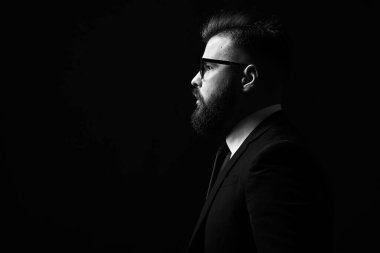 Stüdyoda siyah ceket ve papyon takan yakışıklı, sakallı genç bir adam. Genç bir adamın portresi. siyah ve beyaz resim, boşluğu kopyala