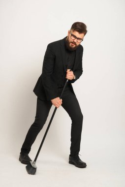 Sakallı, beyaz gömlekli ve elinde siyah baston olan siyah pantolonlu bir adamın portresi..