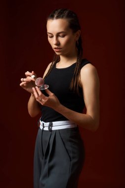 Beyaz bluzlu, siyah pantolonlu, pembe etekli, beyaz bluzlu kırmızı kurdeleli genç bir kadın.