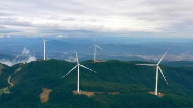 Bir dağın tepesindeki rüzgar türbinlerinin 4K hava görüntüsü