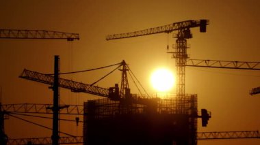 real footage of construction crane silhouette at sunrise time lapse