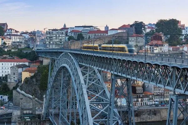 Modern tramvayı olan tarihi çelik köprü manzaralı bir şehir manzarasının üzerinden geçiyor.