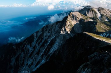 Gün doğumunda Bulutlar ve Derin Gölgeler ile Çarpıcı Dağ Sırtı