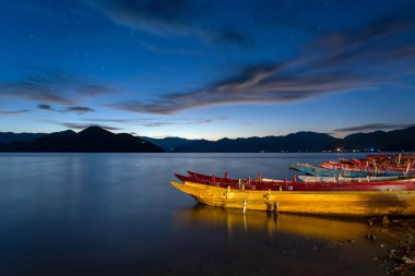 Yunnan 'daki huzur dolu Lugu Gölü üzerinde nefes kesici Yıldızlı Gökyüzü ve Gün Doğumu
