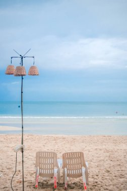 Mavi Gök Altında Boş Sahil Sandalyeleri ve Serene Shoreline Fotoğrafçılığında Beyaz Bulutlar