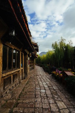 Taş yolu ve kırsal duvarları olan Lijiang Eski Şehir Geçidini daralt