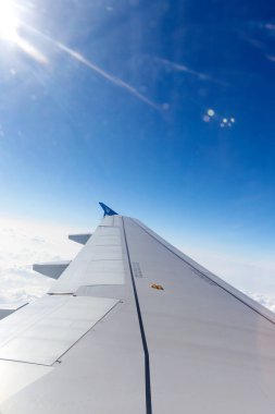 Mavi gökyüzünü ve parlak güneş ışığını kesen uçağın hava görüntüsü