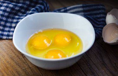 Beyaz tabakta üç çiğ yumurta.